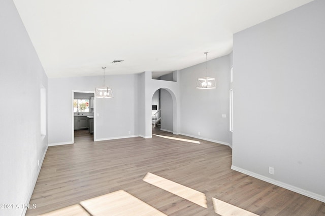 unfurnished room with sink, lofted ceiling, and hardwood / wood-style flooring