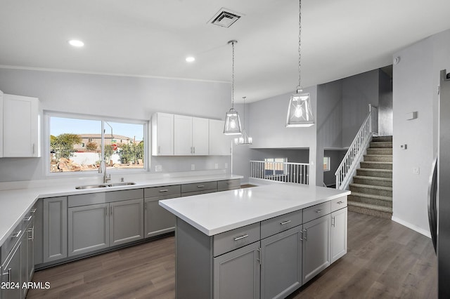 kitchen featuring pendant lighting, white cabinets, sink, gray cabinets, and dark hardwood / wood-style flooring