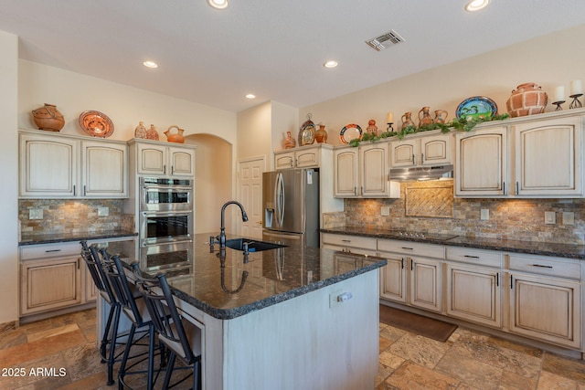 6931 S Four Peaks Way, Chandler, AZ 85249 - kitchen with stainless steel appliances, under cabinet range hood, stone tile floors, recessed lighting, and a breakfast bar area