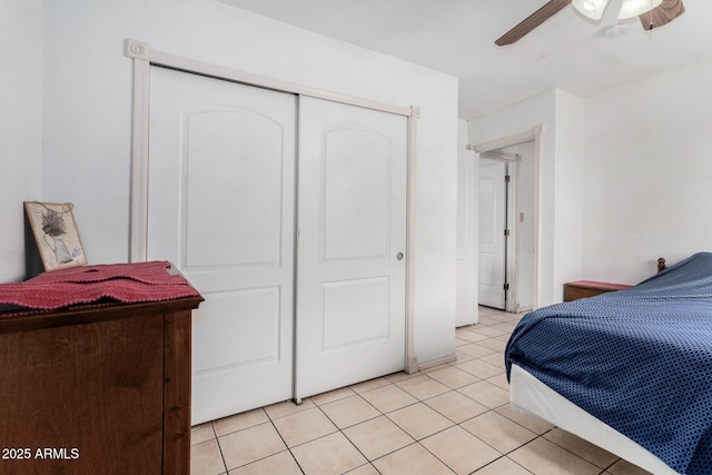 tiled bedroom featuring ceiling fan and a closet