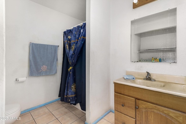 bathroom with tile patterned flooring, vanity, and toilet