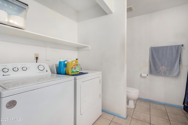 laundry area featuring light tile patterned flooring and washing machine and clothes dryer