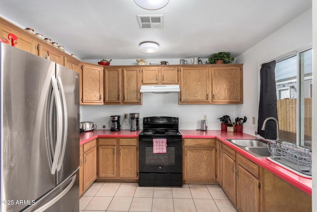 kitchen featuring black electric range oven, light tile patterned floors, stainless steel fridge, and sink