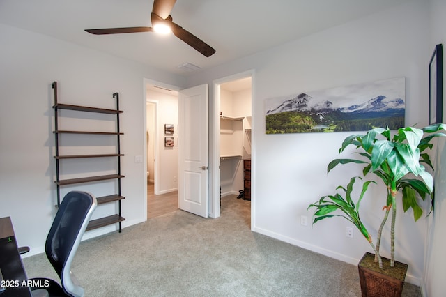 carpeted office space with ceiling fan