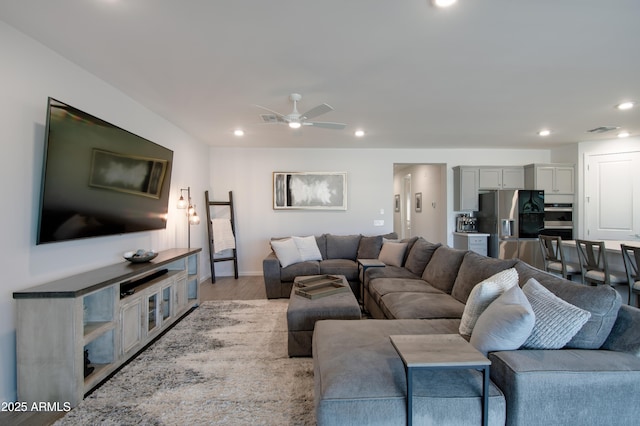 living room featuring ceiling fan and light hardwood / wood-style flooring