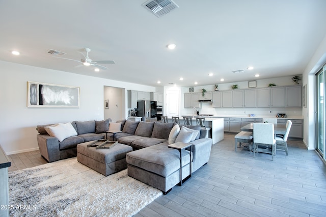 living room featuring ceiling fan and light hardwood / wood-style floors