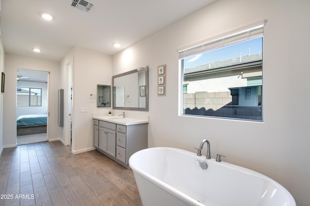 bathroom featuring vanity, hardwood / wood-style floors, and a bathtub