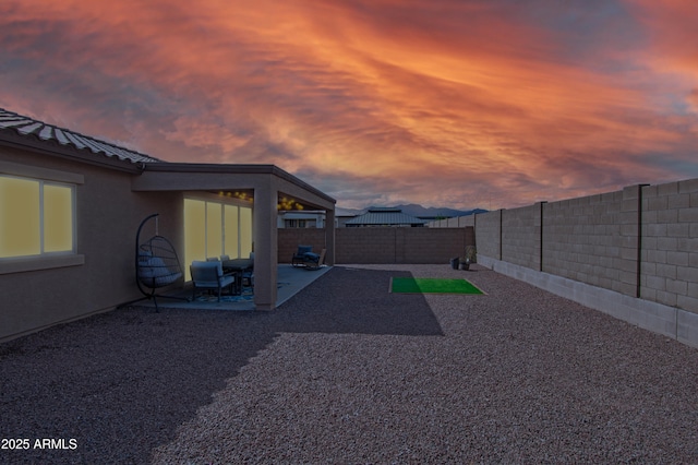 yard at dusk featuring a patio