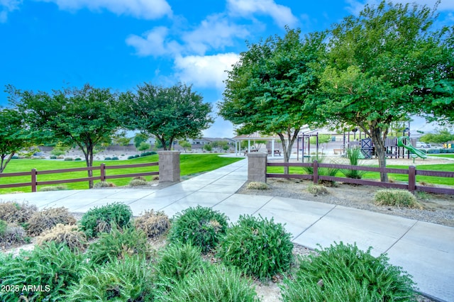 view of property's community with a playground and a lawn