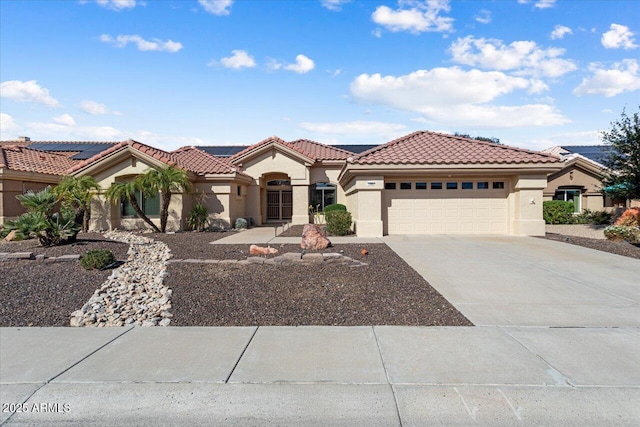 view of front of home featuring a garage, concrete driveway, a tile roof, and stucco siding