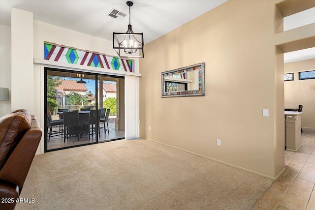 interior space with a chandelier, light carpet, visible vents, and baseboards