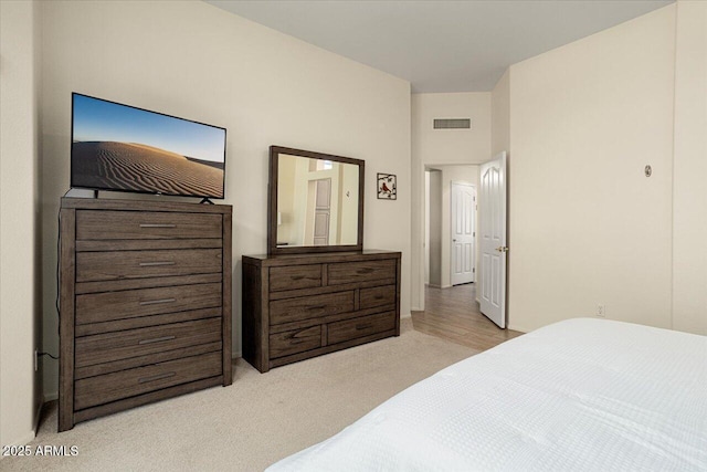 bedroom featuring visible vents and light colored carpet