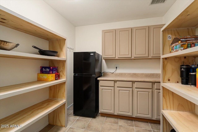 kitchen with freestanding refrigerator, light countertops, and open shelves