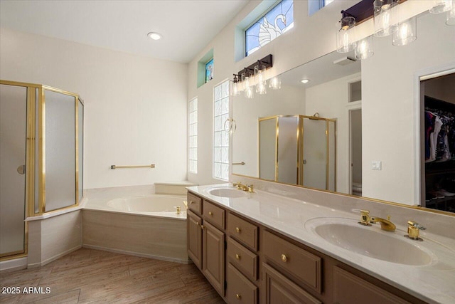 full bathroom featuring wood finished floors, a sink, a shower stall, and a bath