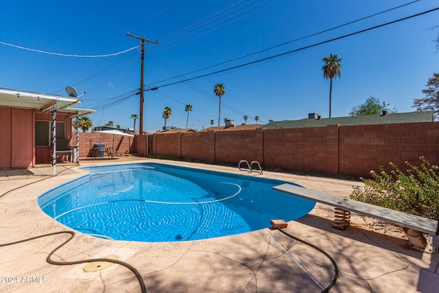 view of pool featuring a diving board and a patio