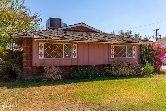 view of property exterior featuring central air condition unit and a lawn