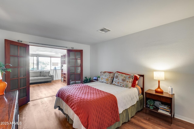 bedroom with french doors and wood-type flooring