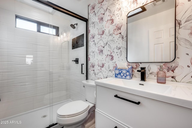 bathroom with an enclosed shower, vanity, and toilet