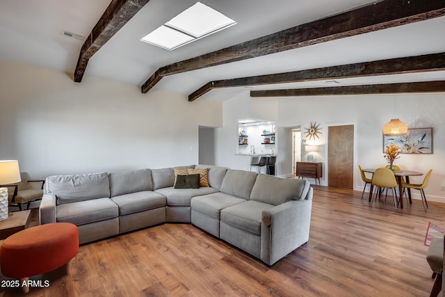 living room featuring beamed ceiling and hardwood / wood-style floors