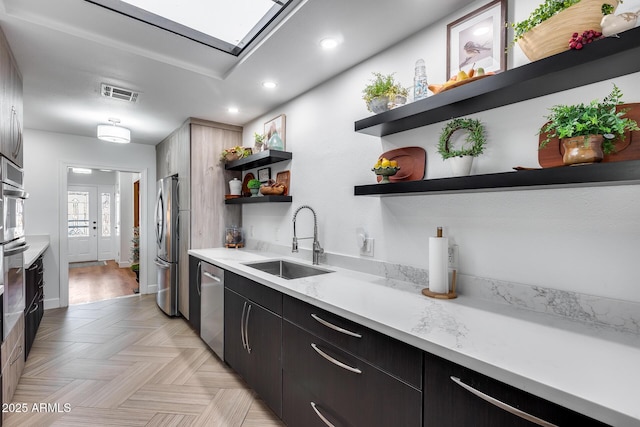 kitchen featuring stainless steel appliances, light parquet floors, and sink