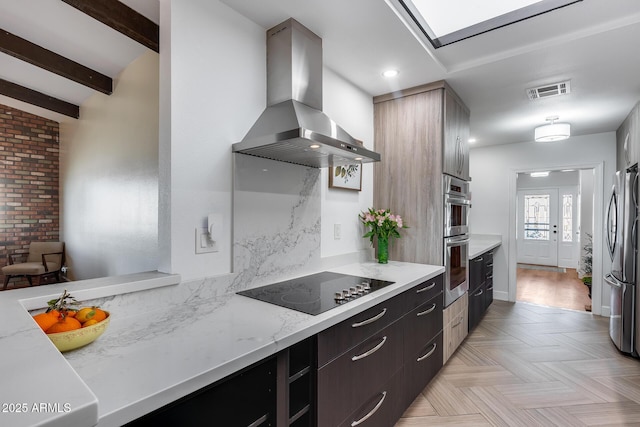 kitchen with island exhaust hood, dark brown cabinetry, light stone countertops, lofted ceiling with beams, and appliances with stainless steel finishes