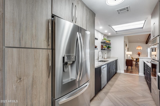 kitchen featuring sink, stainless steel appliances, and a skylight