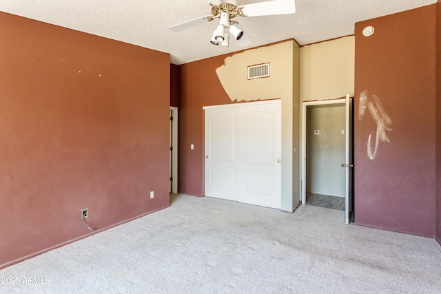 unfurnished bedroom with visible vents, ceiling fan, carpet floors, and a textured ceiling