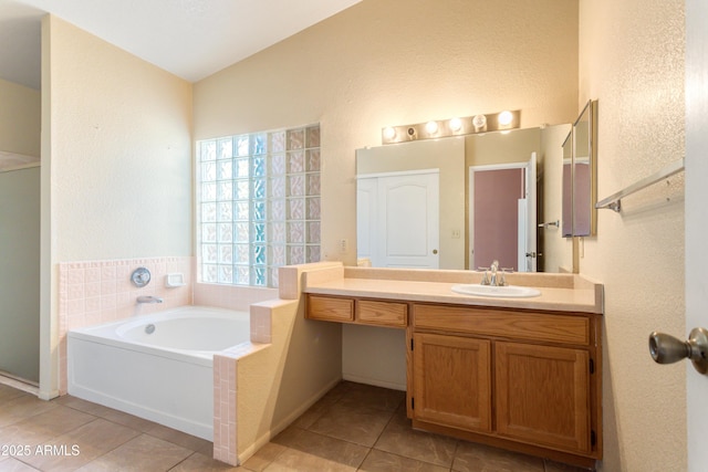 full bathroom featuring a shower stall, a bath, vanity, tile patterned floors, and a textured wall