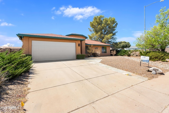 view of front of property with an attached garage, driveway, and stucco siding