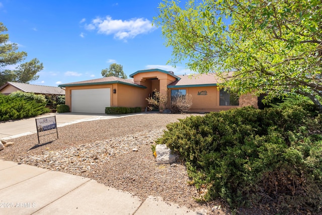 single story home featuring concrete driveway, stucco siding, and an attached garage