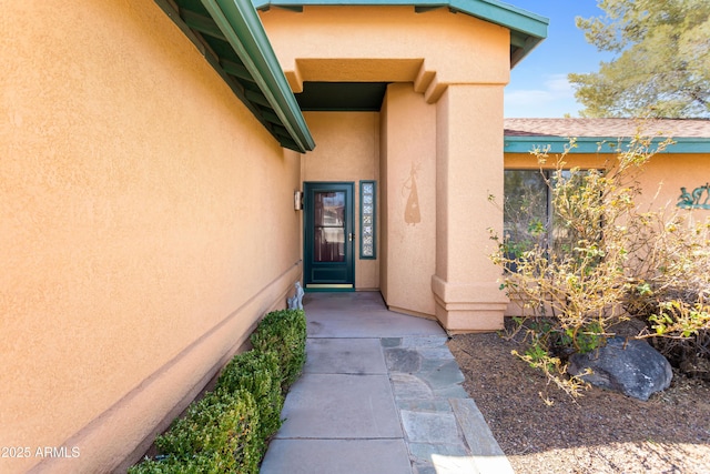 view of exterior entry featuring stucco siding