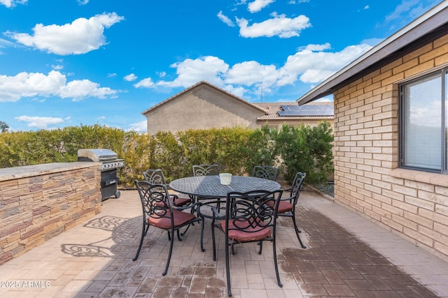 view of patio with an outdoor kitchen and a grill