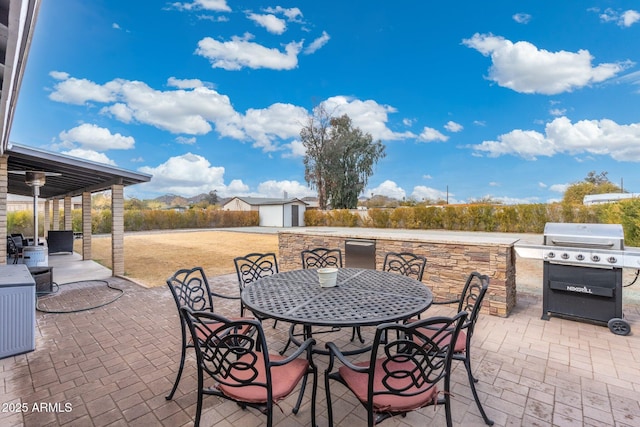 view of patio featuring area for grilling and a storage unit