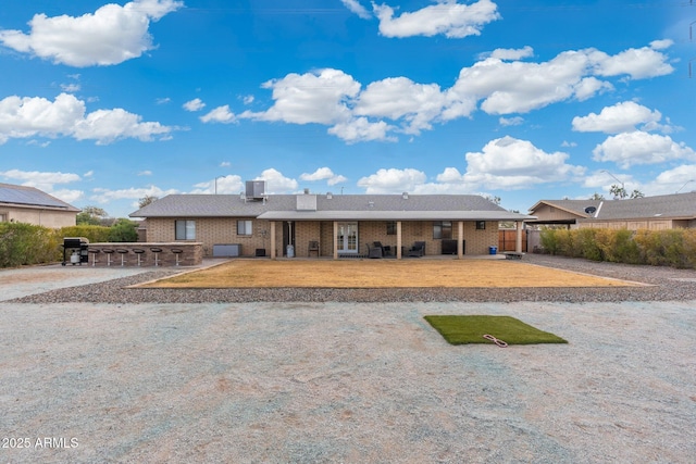 single story home featuring exterior bar, central AC unit, and a patio area