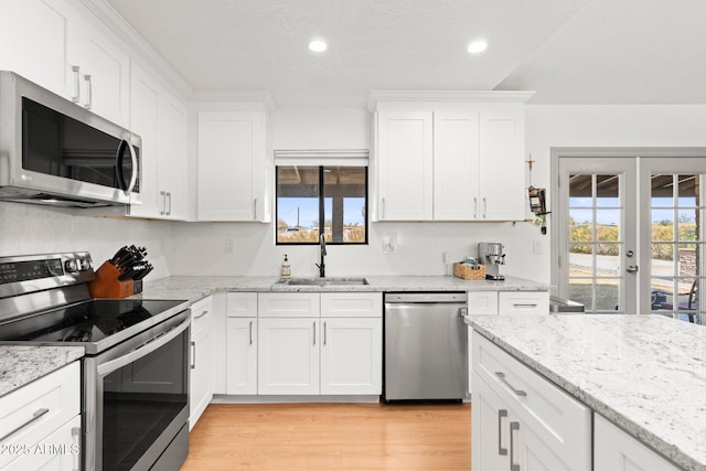 kitchen with appliances with stainless steel finishes, sink, and white cabinets