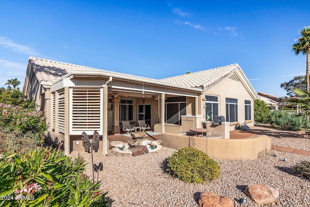 rear view of house with a ceiling fan, a patio area, a tiled roof, and stucco siding