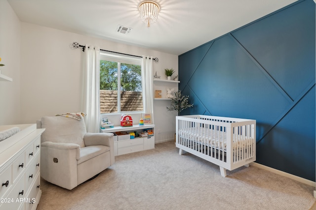 bedroom with a nursery area and light carpet