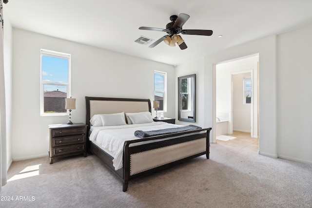 bedroom with multiple windows, ceiling fan, ensuite bathroom, and light carpet