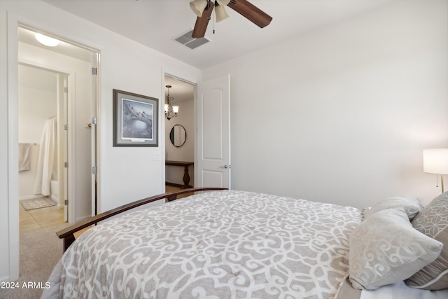 bedroom with ceiling fan with notable chandelier, connected bathroom, and light colored carpet