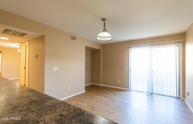 empty room with ceiling fan and light hardwood / wood-style flooring