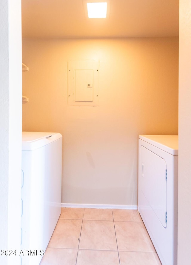 clothes washing area with light tile patterned flooring, independent washer and dryer, and electric panel