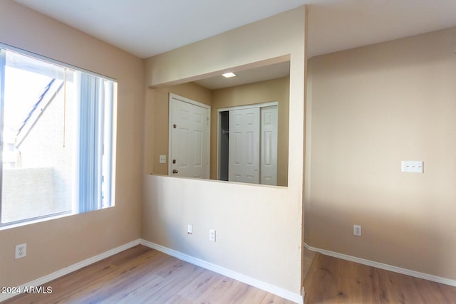 spare room with light wood-type flooring and a wealth of natural light