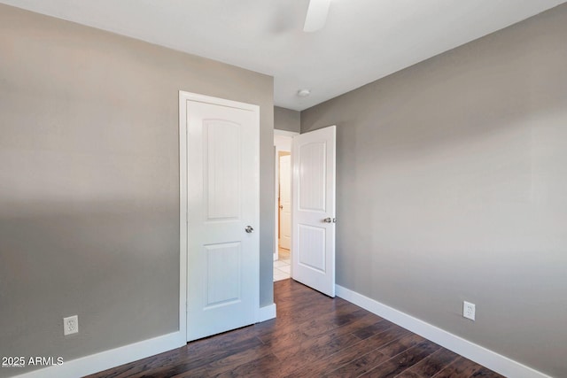 4427 W Crittenden Ln, Phoenix, AZ 85031 - unfurnished bedroom featuring baseboards, dark wood-style flooring, and a ceiling fan