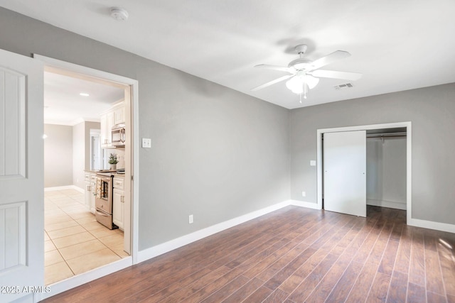 4427 W Crittenden Ln, Phoenix, AZ 85031 - unfurnished bedroom with baseboards, a closet, wood finished floors, and ceiling fan