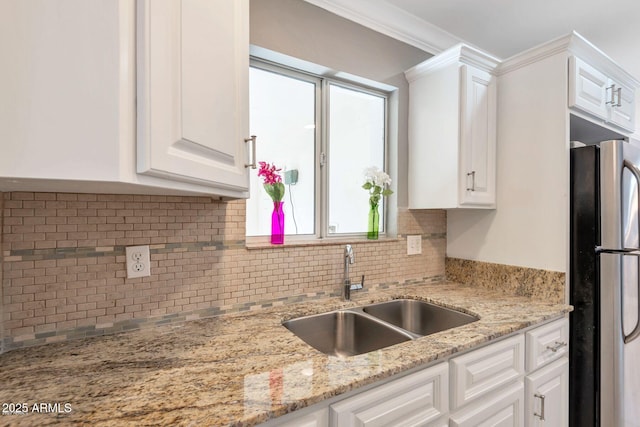 4427 W Crittenden Ln, Phoenix, AZ 85031 - kitchen featuring freestanding refrigerator, a sink, white cabinetry, tasteful backsplash, and light stone counters