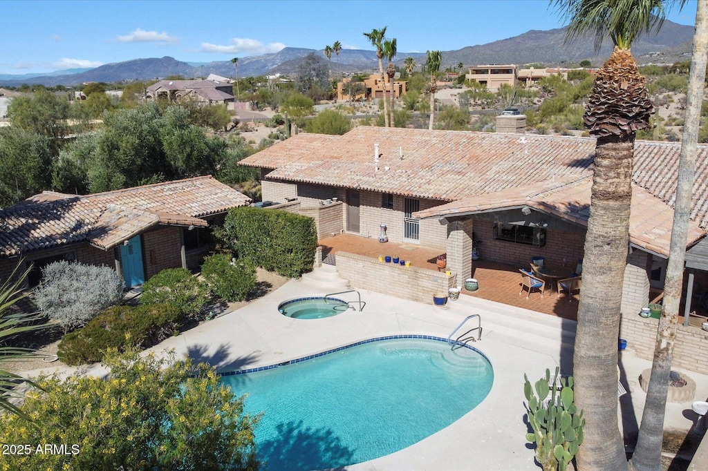 view of swimming pool featuring a mountain view, a patio area, and a community hot tub