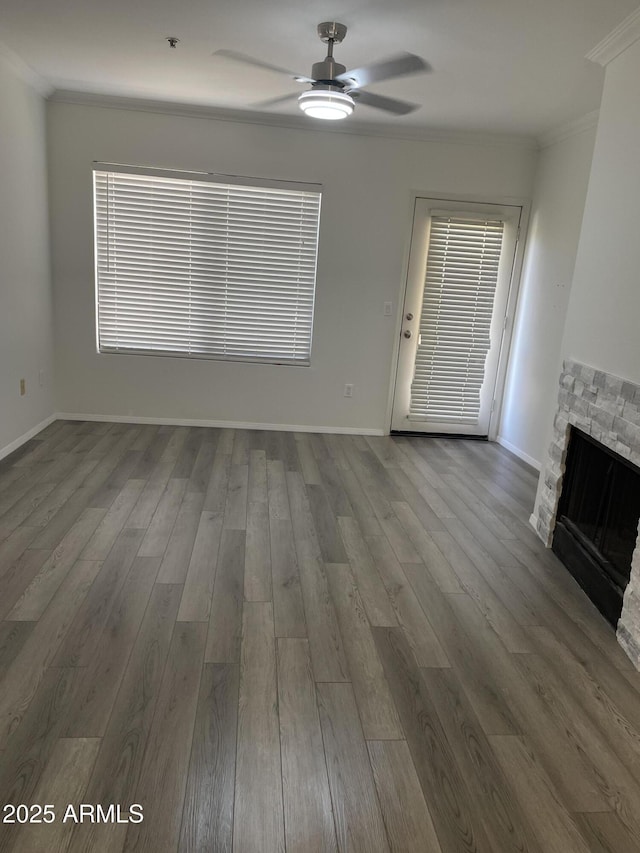 unfurnished living room featuring ornamental molding, wood finished floors, a fireplace, baseboards, and ceiling fan