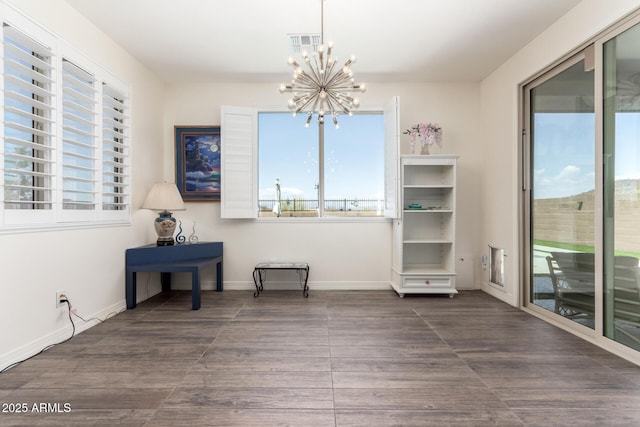 unfurnished dining area featuring plenty of natural light, visible vents, wood finished floors, and a notable chandelier