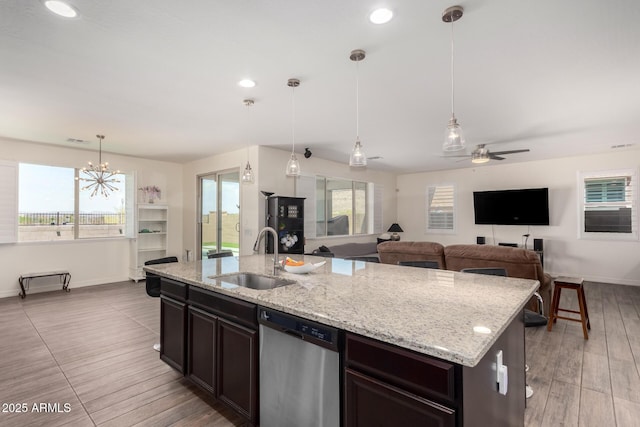 kitchen featuring a sink, stainless steel dishwasher, baseboards, and plenty of natural light