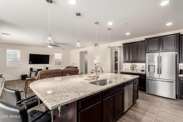 kitchen featuring a ceiling fan, a sink, visible vents, appliances with stainless steel finishes, and light stone counters